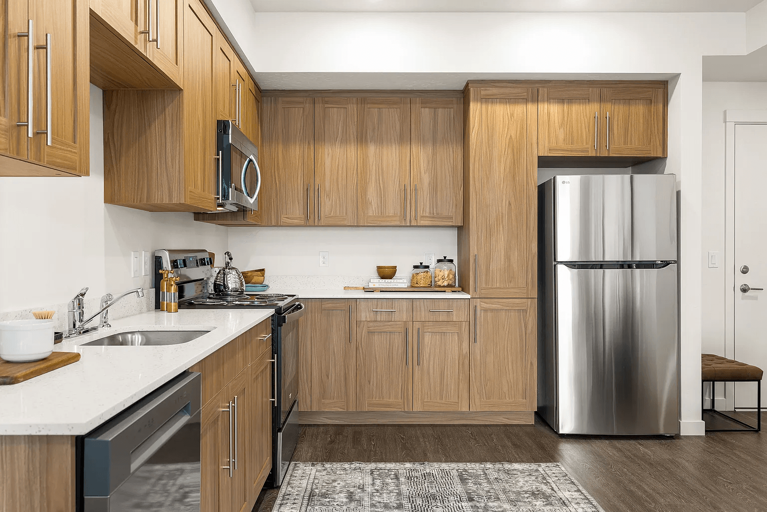 A kitchen with wooden cabinets and a stainless steel refrigerator.